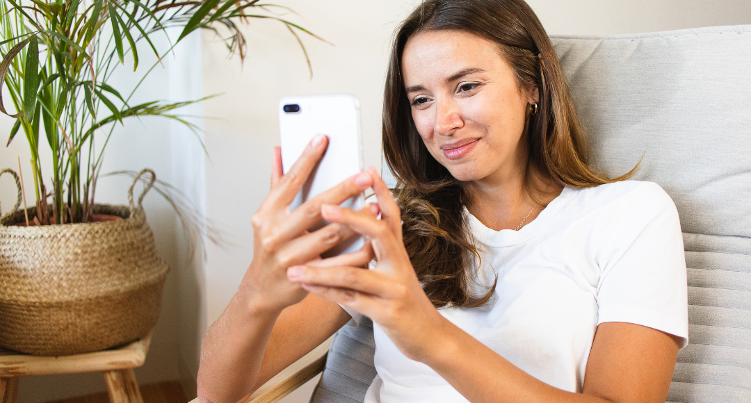 Pige med brunt hår i hvid tshirt har lige skfitet mobilabonnement til velkommen .png