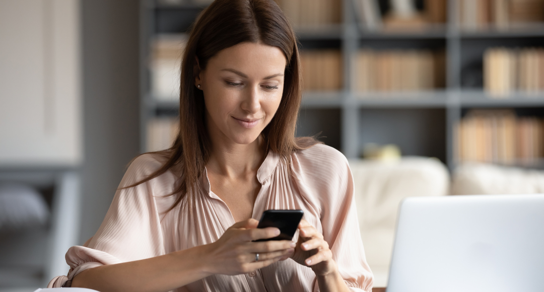 mørkhåret kvinde i lyserød skjorte ser hvordan hun betaler for mobilt bredbånd.png