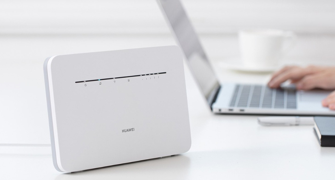 Router placeret foran mand der sidder på computer er ved at installere den lynhurtigt
