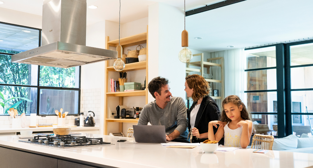 familie i stue på tre personer hvor far tjekker op på familiens aftale og pris hos Velkommen på sin computer.png