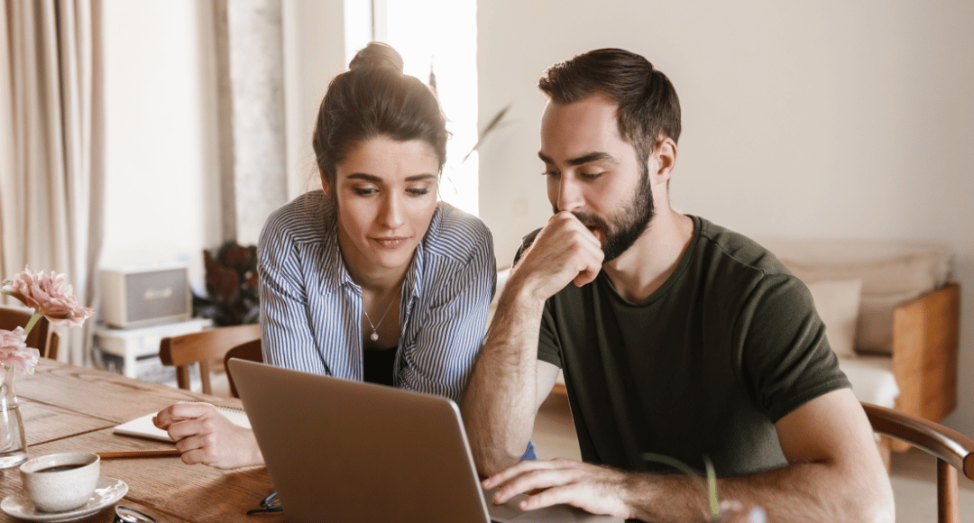 Kvinde med knold og mørkt hår og mand med mørkt hår er ved at få udbetalt deres tilgodehavende på deres comåuter via selbetjening.png