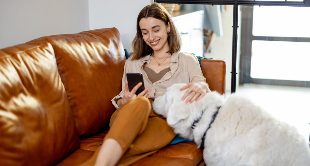 kvinde sidder i sofa med sin hund og tjekker hendes beregning af dataforbrug .png