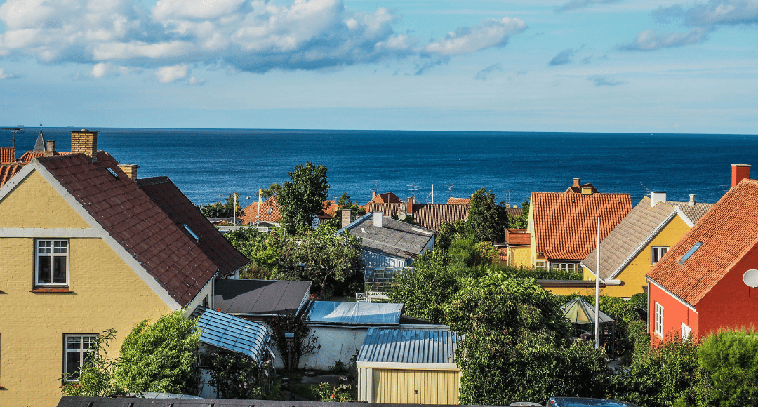Huse i blandt andet gule og røde farver, der er placeret ud til vandet 