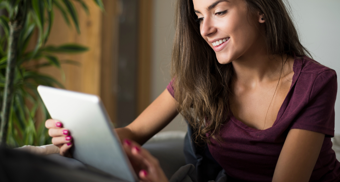 kvinde i rød t-shirt kigger på sine regninger på ladeboks og el fra Velkommen.png