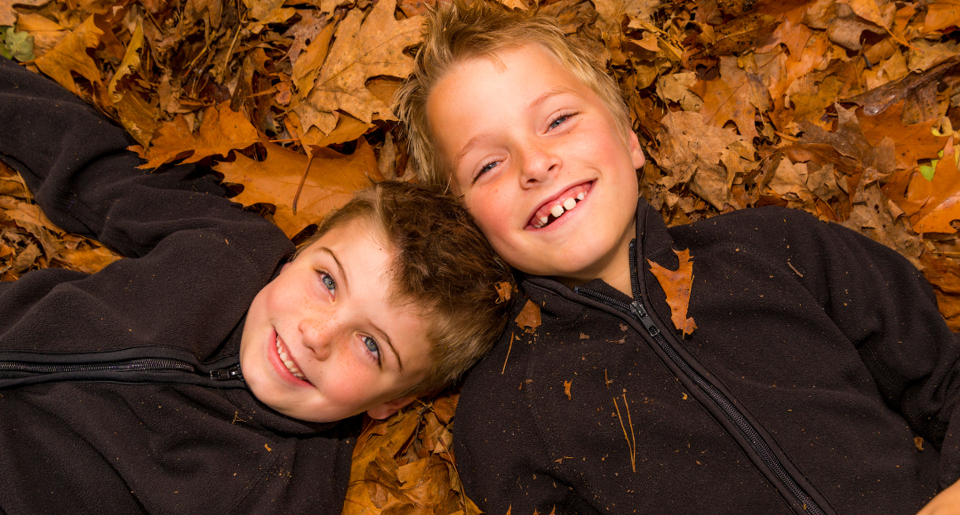 To glade drenge, der ligger i efterårsblade og ikke har den fjerneste anelse om, hvilke betalingsmetoder velkommen har.
