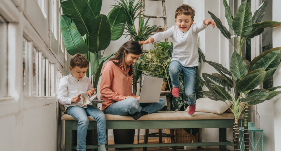 kvinde med sine to drenge der sidder blandt planter og er online på mobilt bredbånd fra velkommen med simkort.png