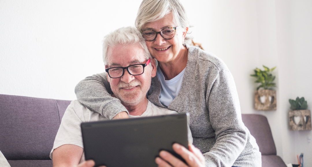 ældre par kigger på deres regning fra velkommen på tablet, hvor de kan se deres aftagenummer